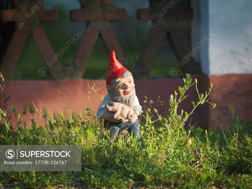 Garden gnome holding piglet