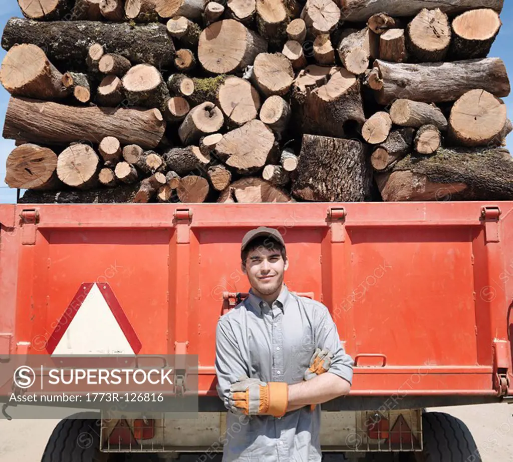 Man standing in front of lorry with logs