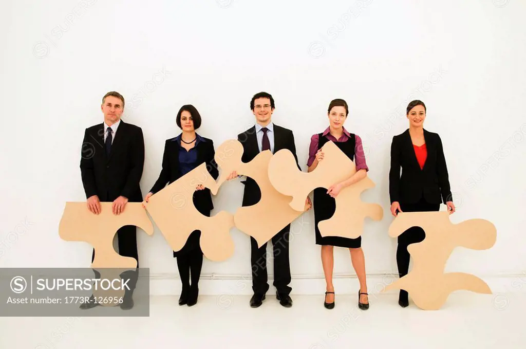 Group of workers hold jigsaw pieces