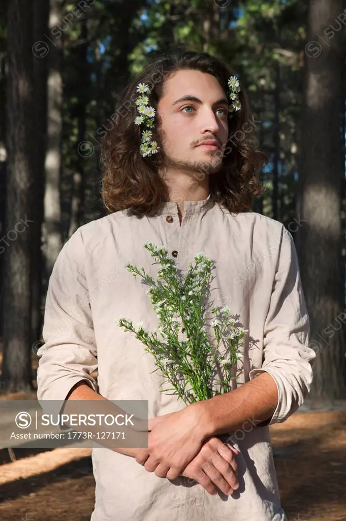 Man holding flowers in forest