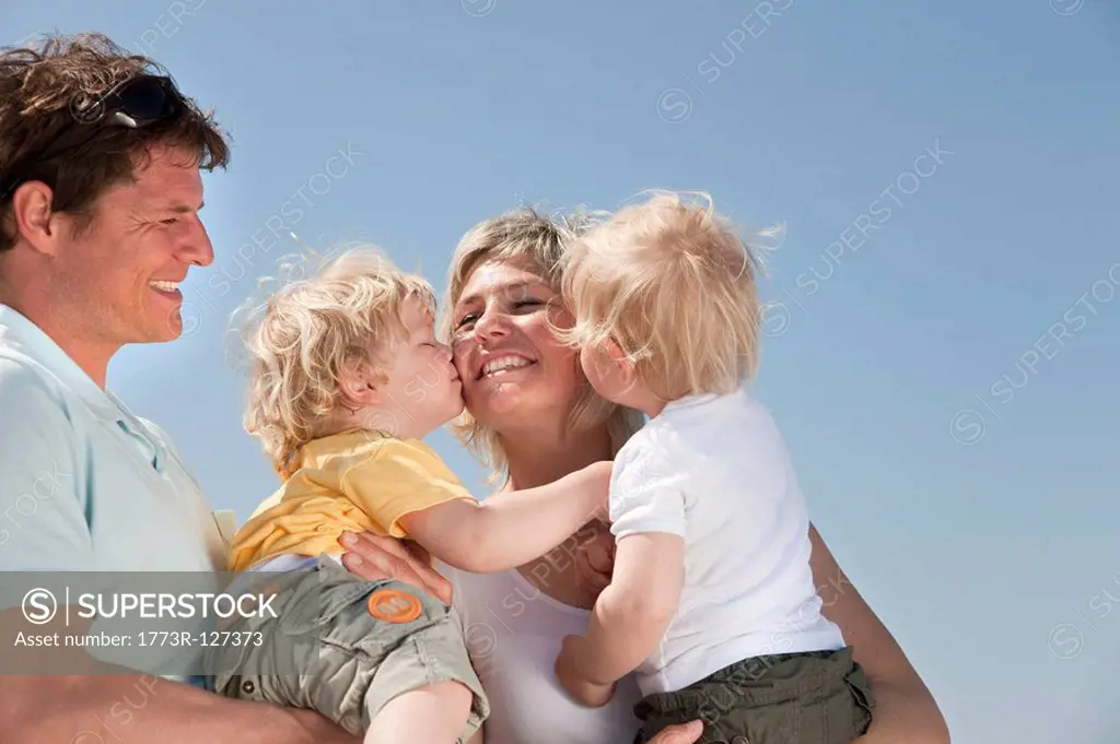 Family with twins kissing