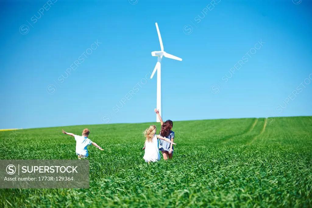 Wind turbine and childrens play in field