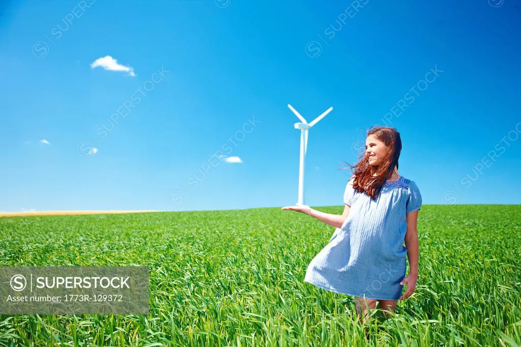 Girl on field with wind turbine