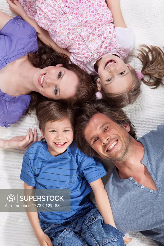 Happy family lying on rug
