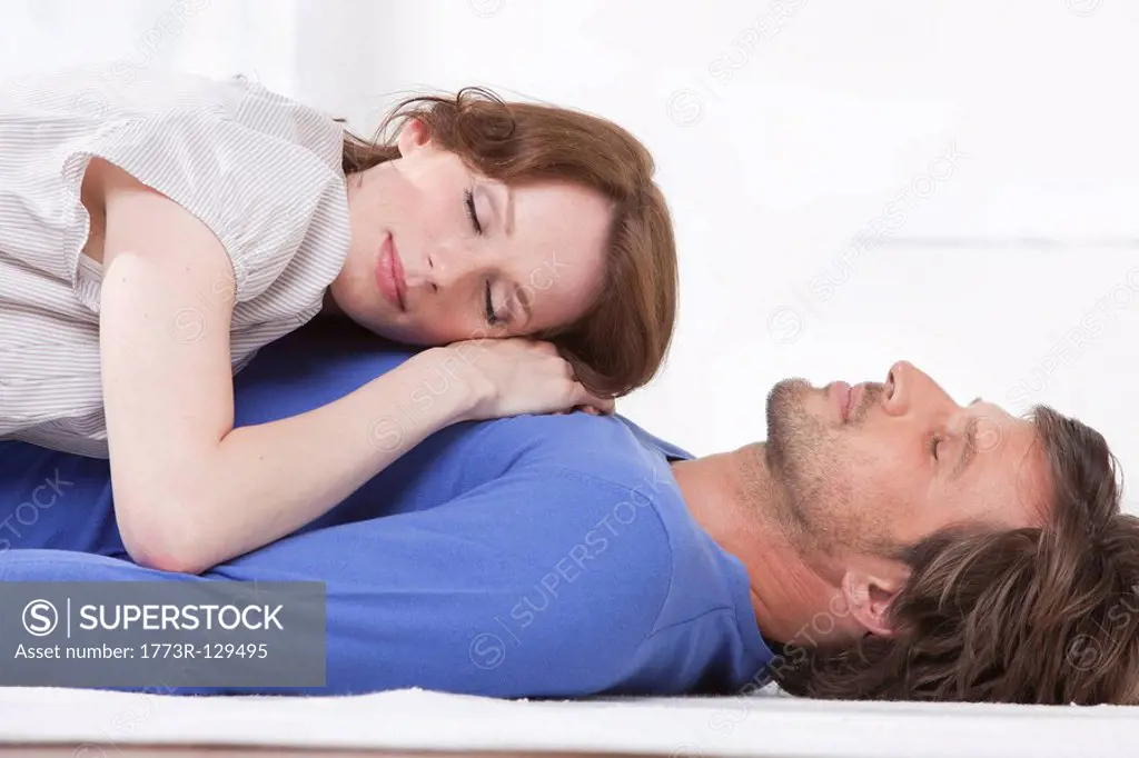 Side view of couple relaxing on rug