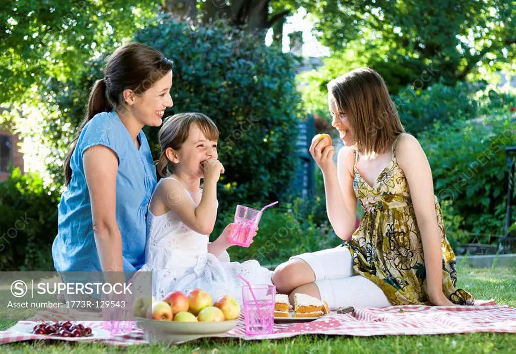 Happy mother and daughters at picnic