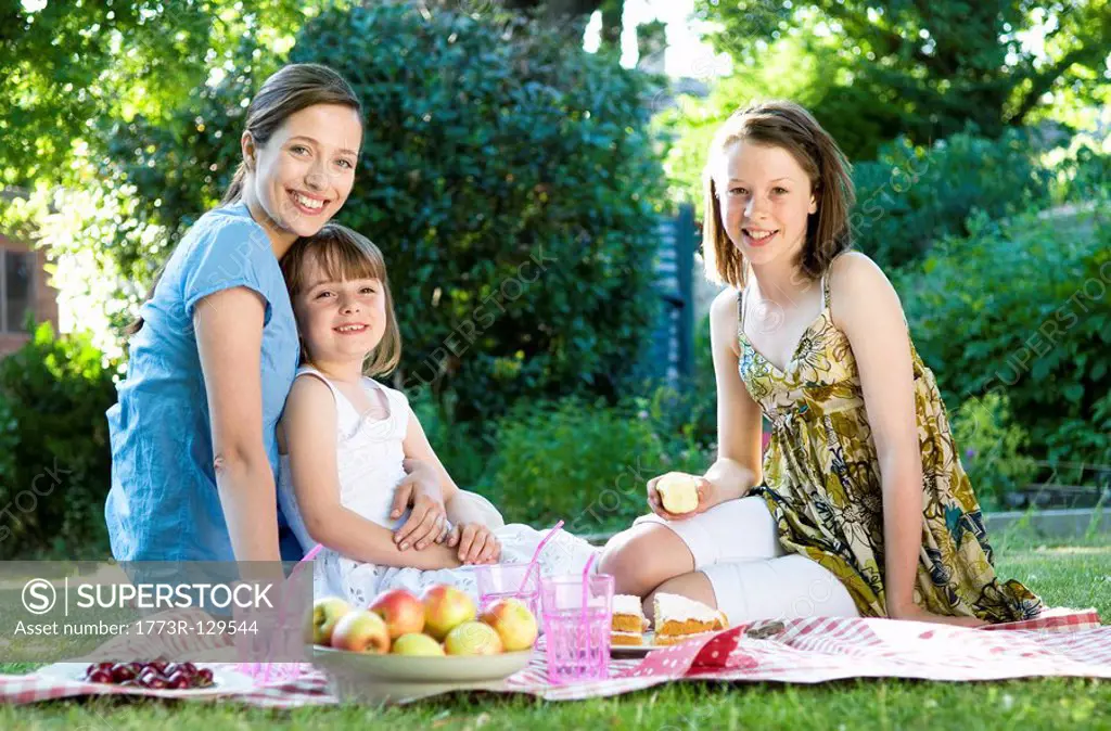Happy mother and daughters at picnic