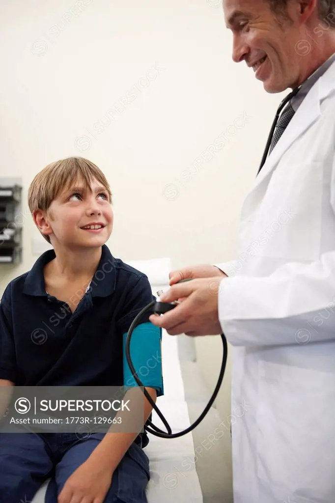 Doctor taking young boy´s blood pressure