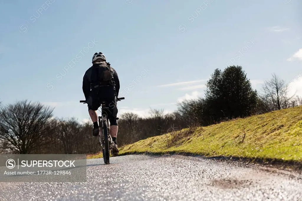 Man riding bike on countryside road