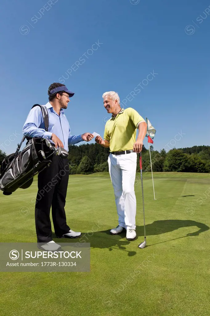 Golfer giving his card to the caddy