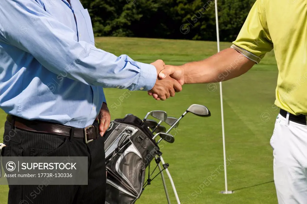 Golfer and caddy shaking hands