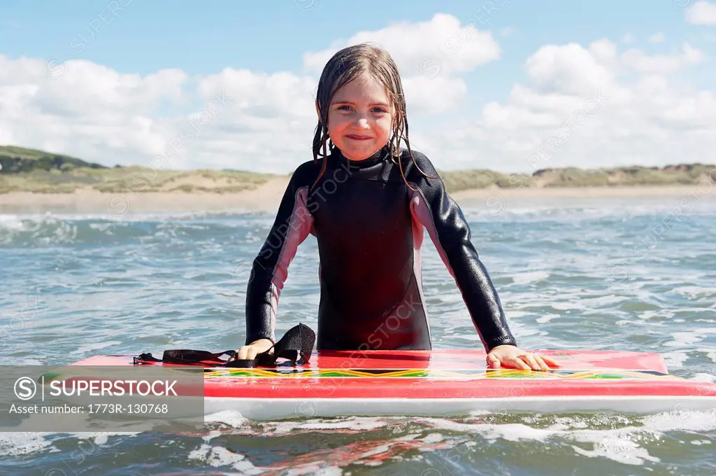 Young girl in the sea with surf board