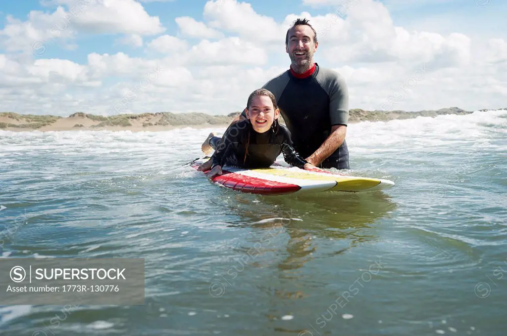 Father and daughter surfing in the sea