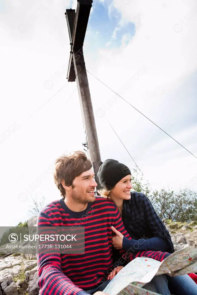 Couple with map sitting under cross
