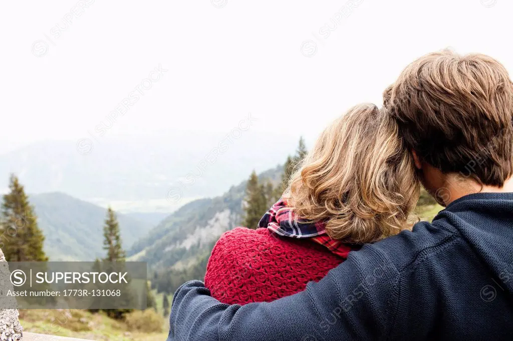 Man hugging woman watching landscape