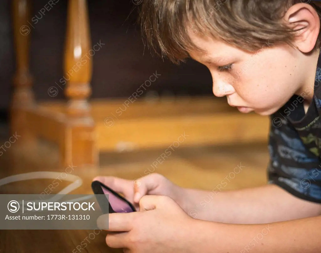 Boy portable gaming on floor