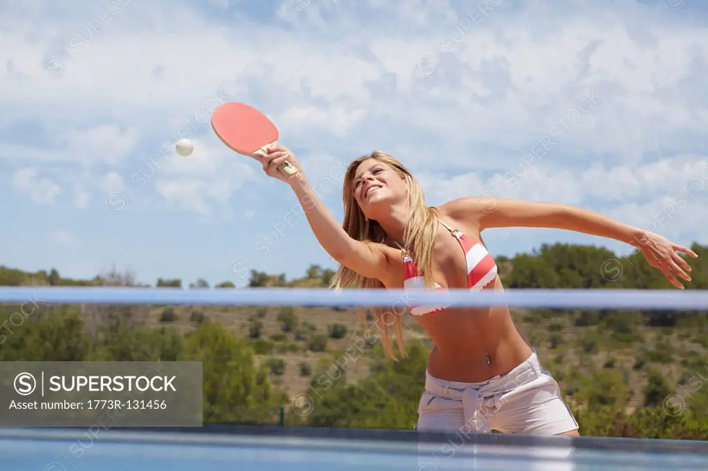 Woman in a game of table tennis outdoors
