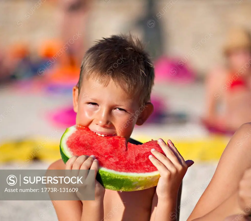 Kids eating watermelon at the beach