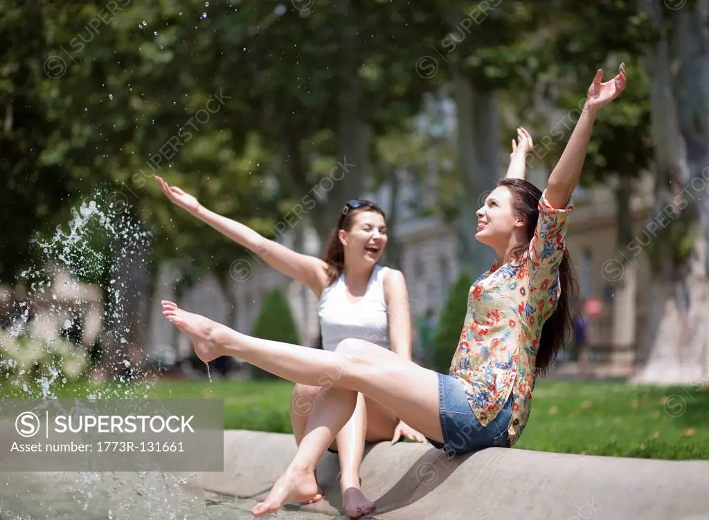 Young women splashing in a fountain