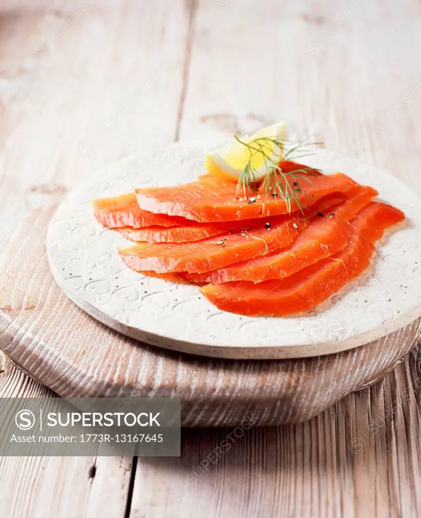 Smoked salmon slices with black pepper, dill and lemon