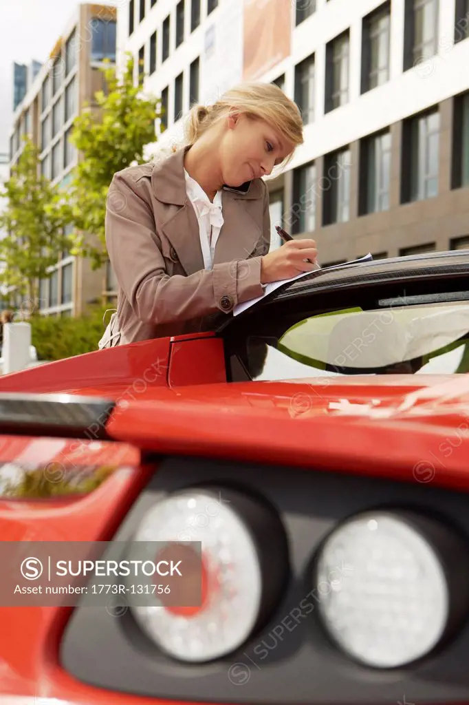 Business woman on mobile phone with car