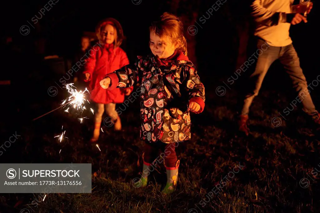 Girls holding sparklers smiling