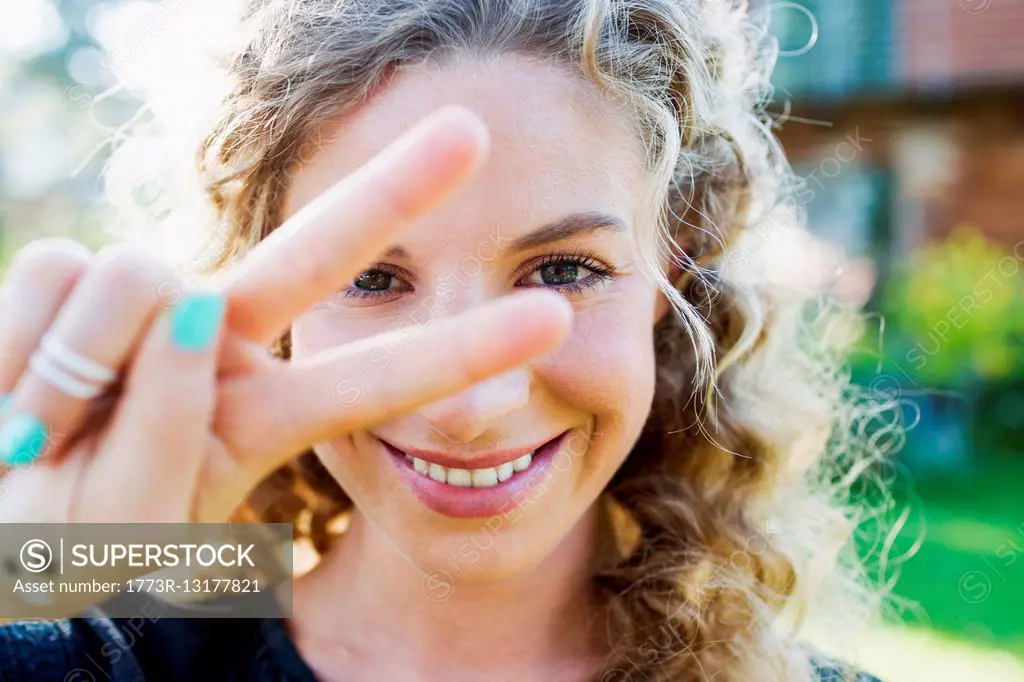 Young woman making peace sign with hand