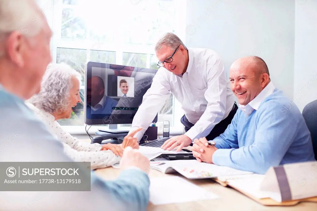 Business men in office having discussion with senior couple
