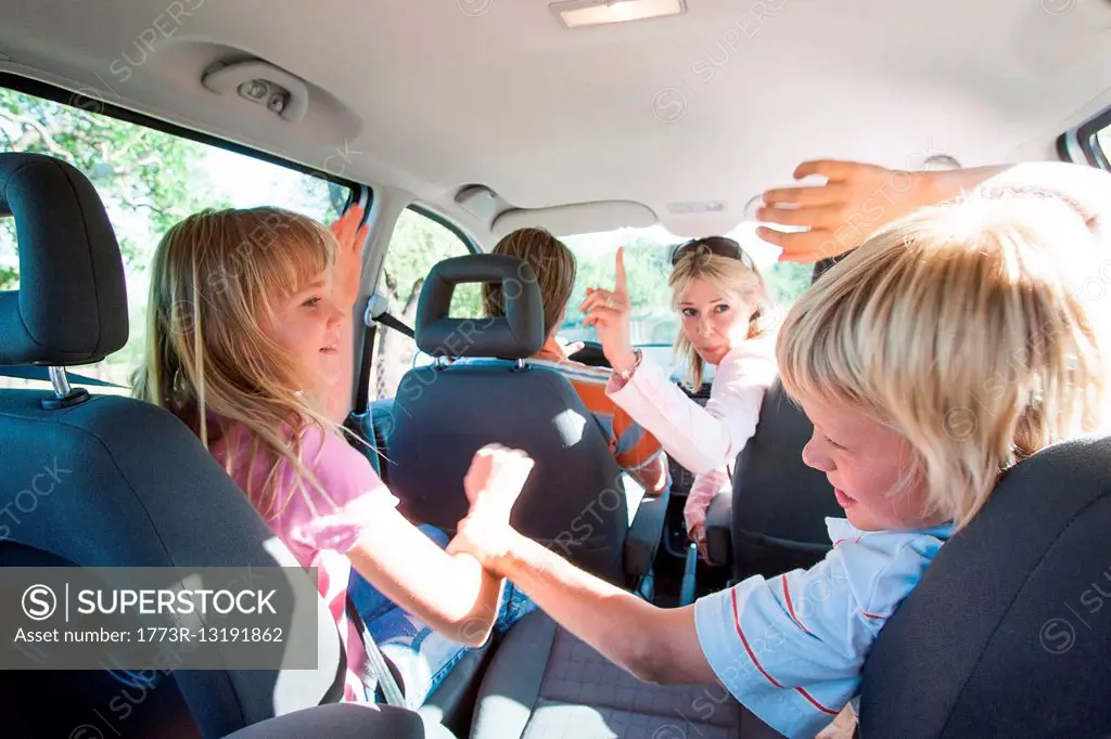 Children fighting in back seat of vehicle on road trip