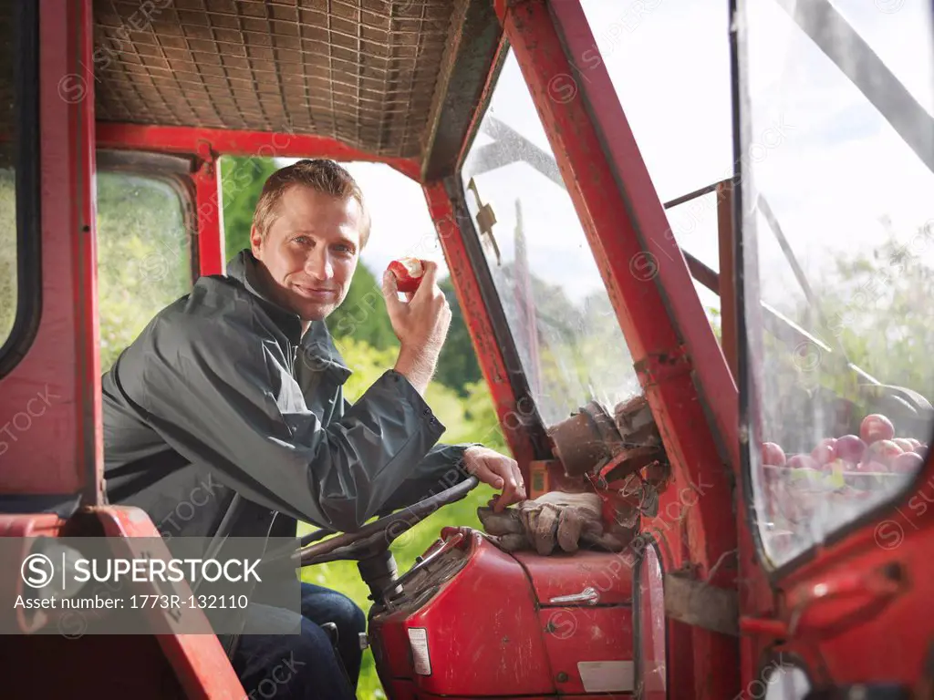Farmer in tractor eating apple