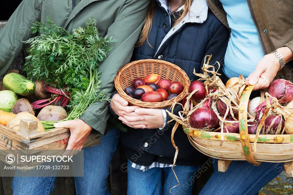 Family holding vegetables