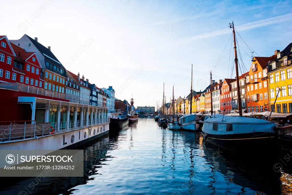 Traditional townhouses and moored boats on canal waterfront, Copenhagen, Denmark