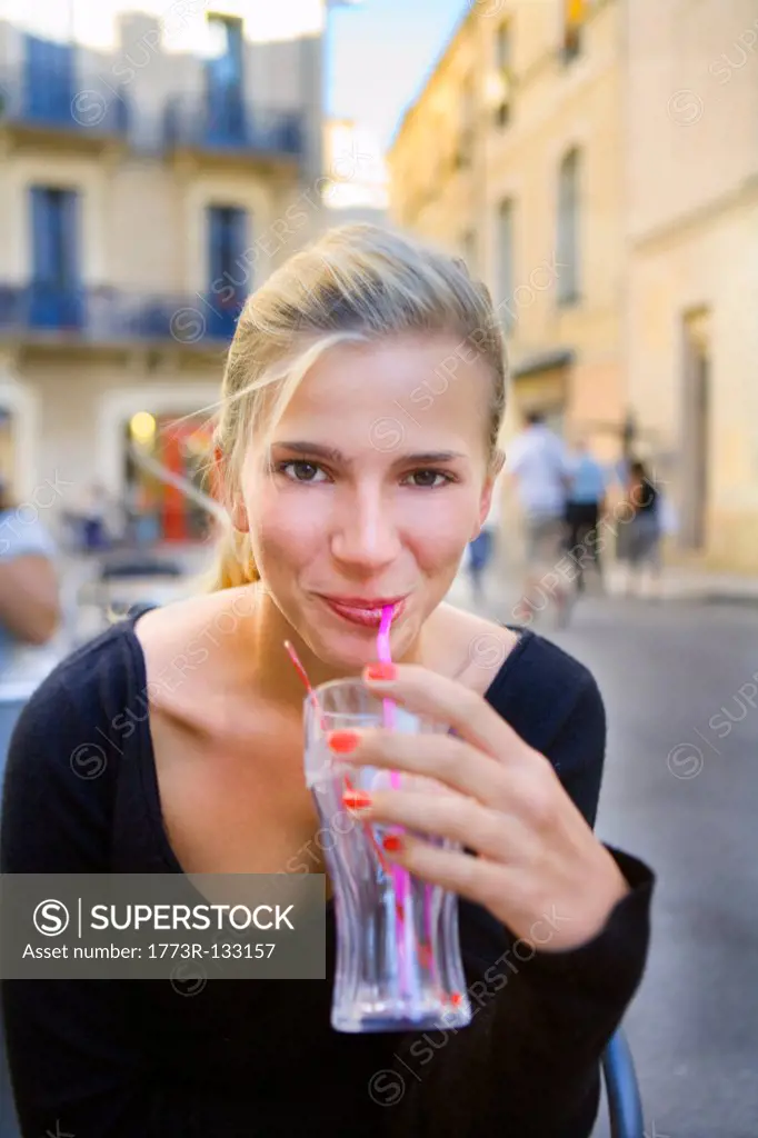 Portrait young woman with drink at cafe