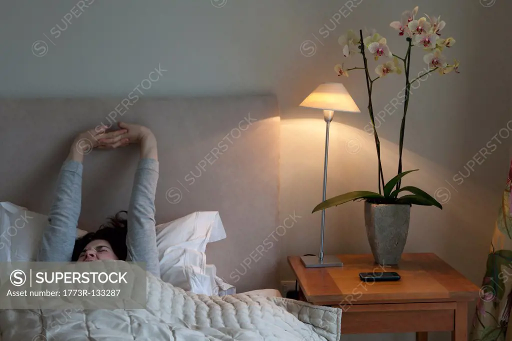 Young woman yawning and stretching