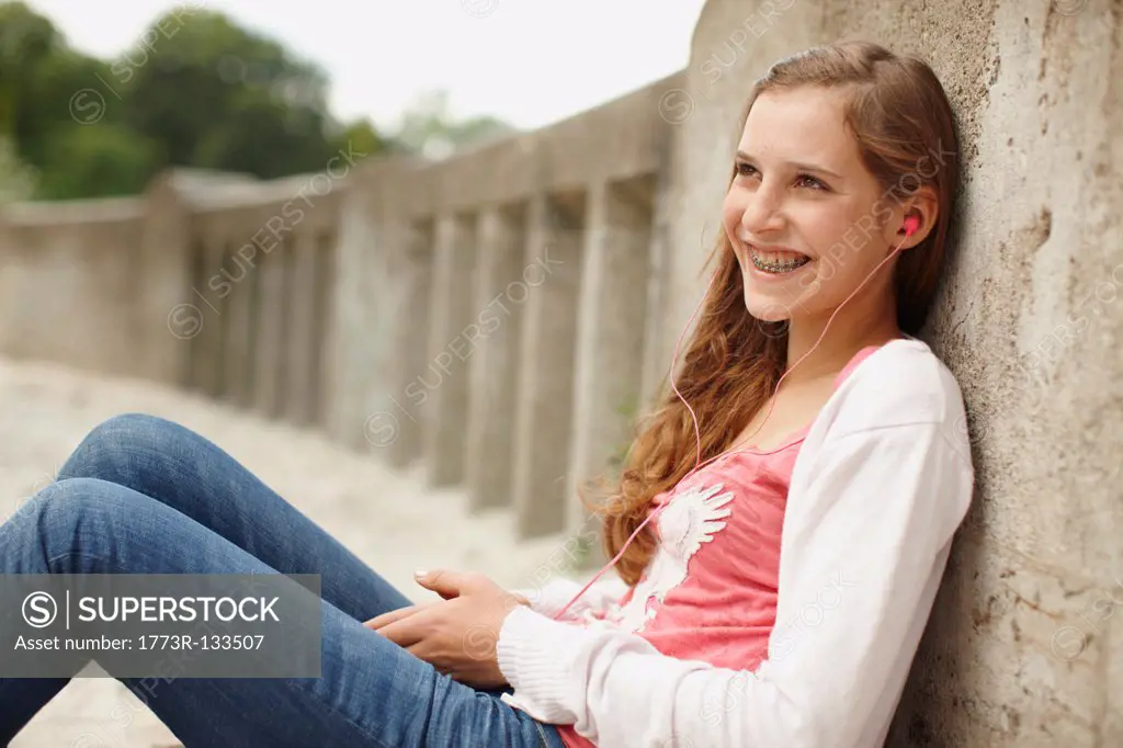 Young girl sitting listening to ipod