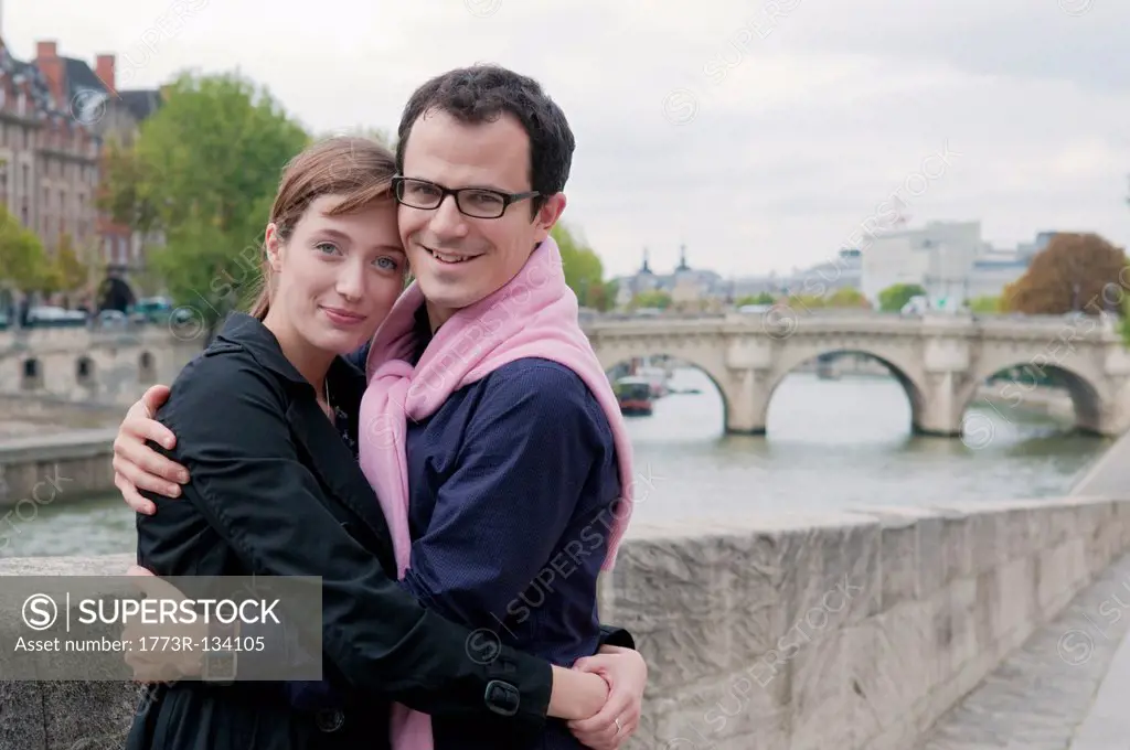 Couple embrace on banks of the Seine