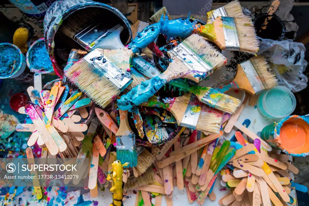 Overhead view of paint brushes and stirrers in surfboard maker's workshop