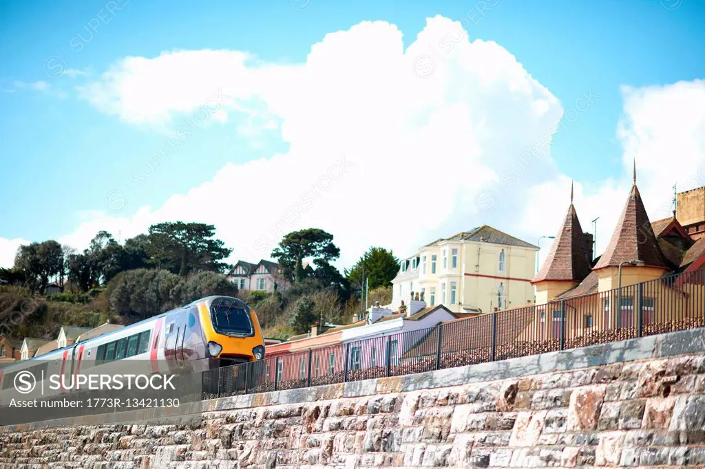 Passenger train on coastal railway line, Devon, UK