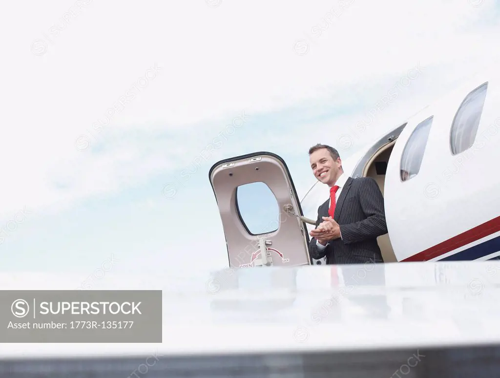 Businessman exiting corporate jet