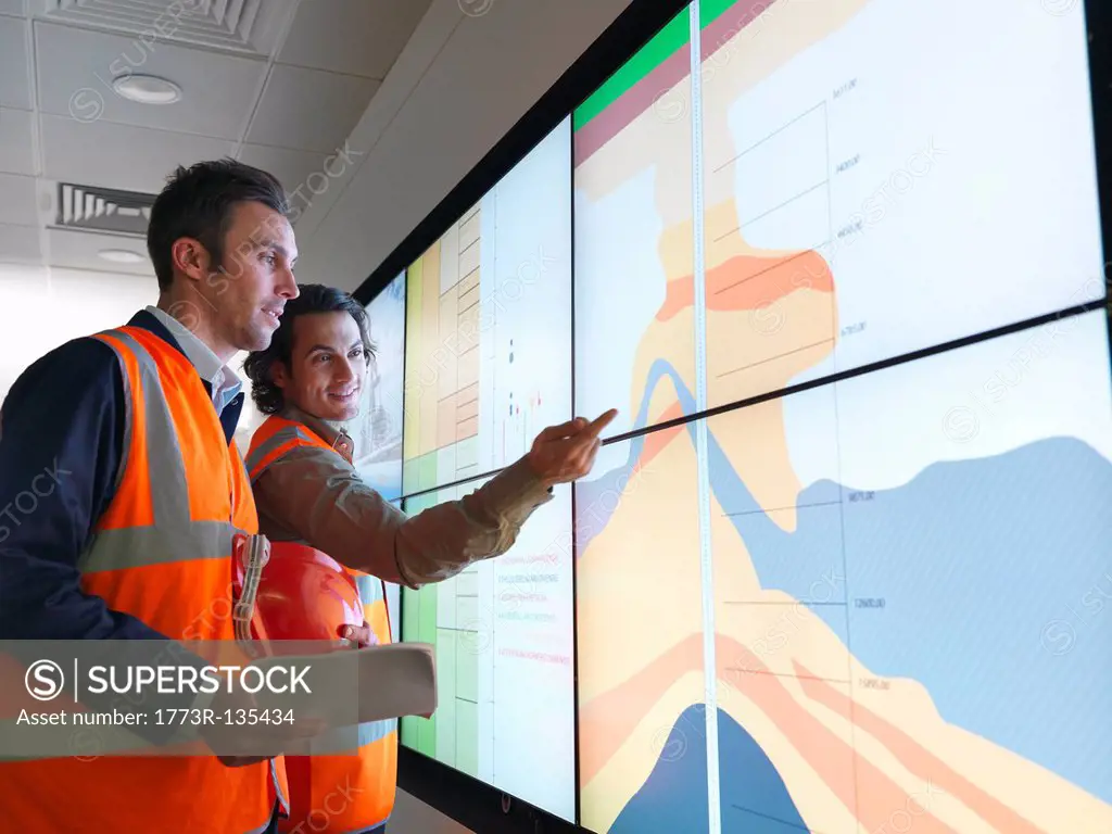 Oil workers with geology screen
