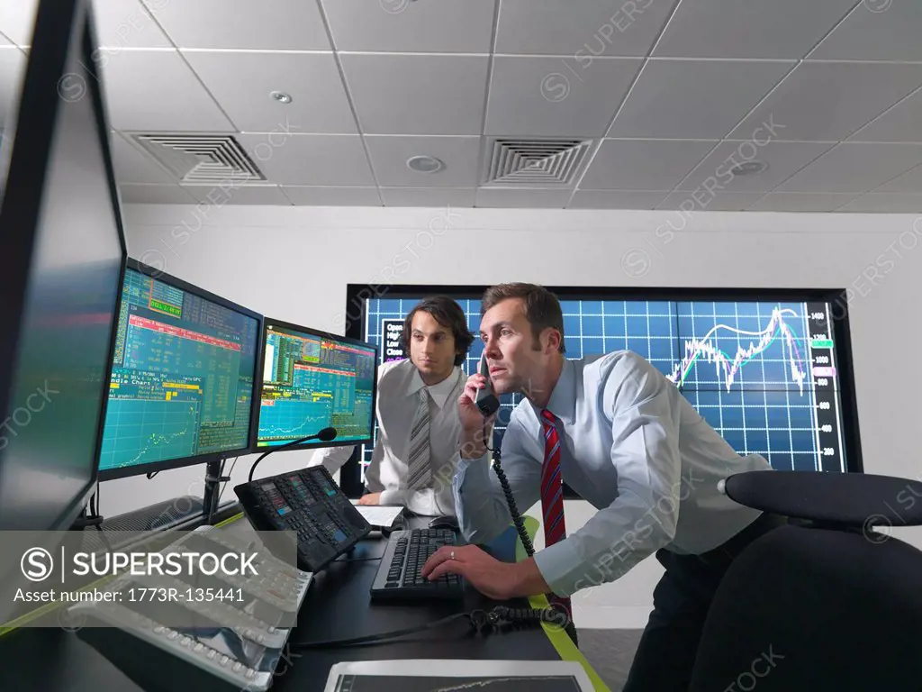 Financial traders with screens