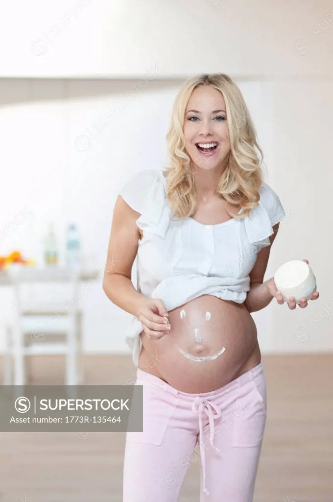 Pregnant woman creaming belly