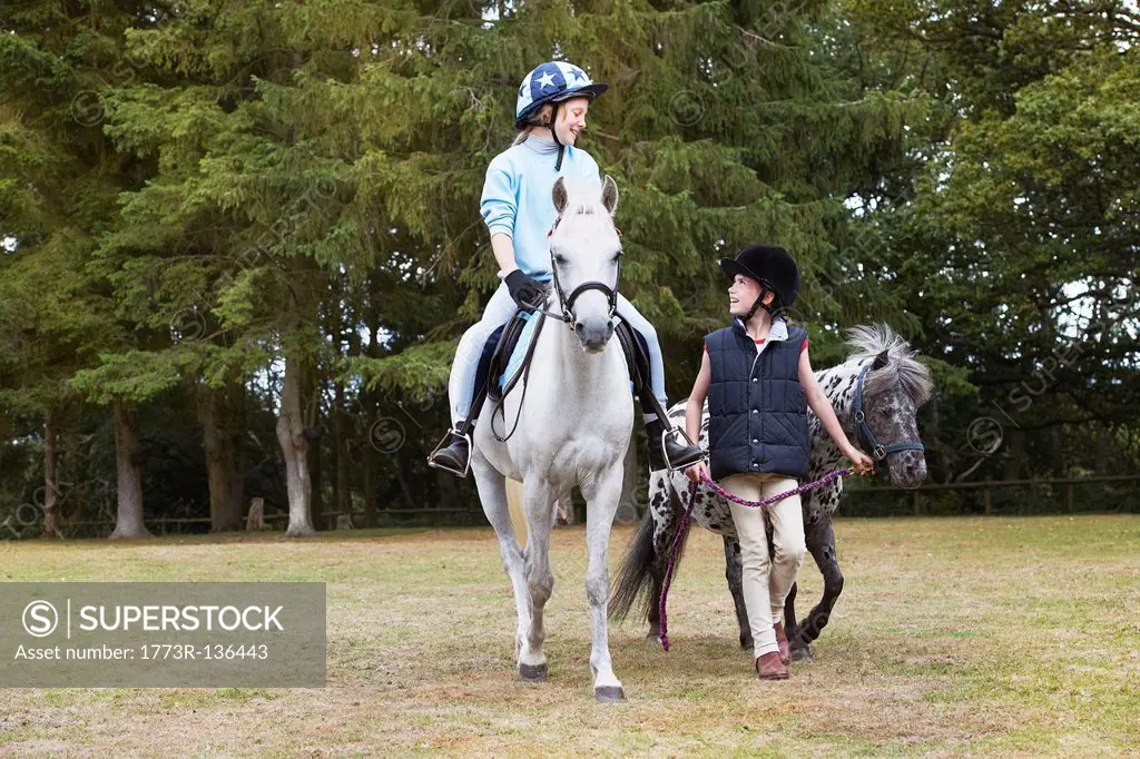 Two girls out riding ponies