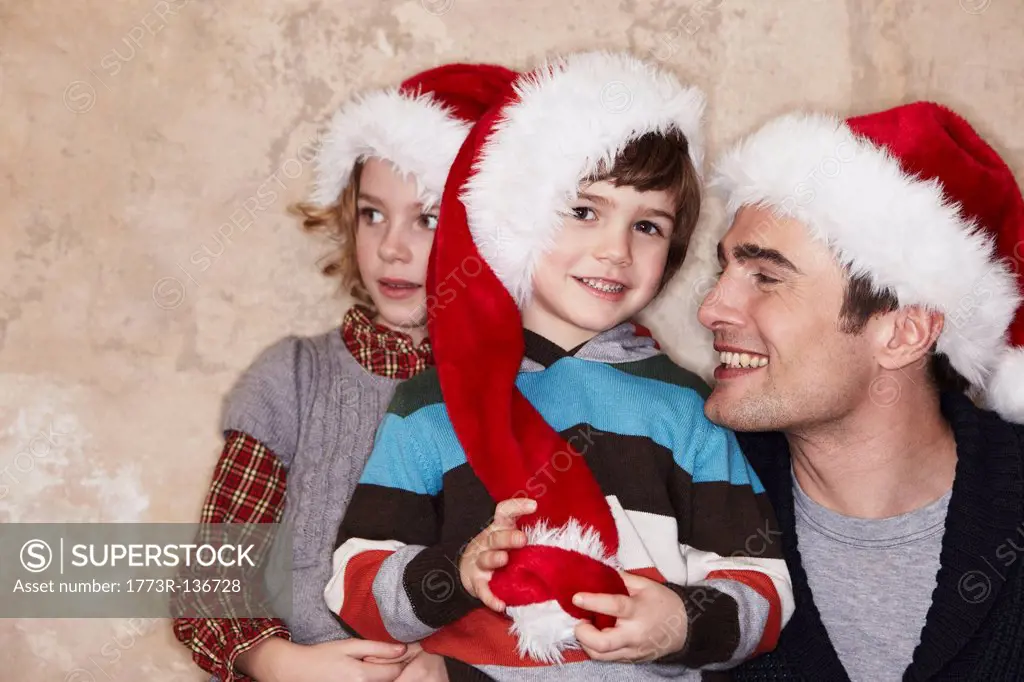 Father and Kids wearing Santa hats