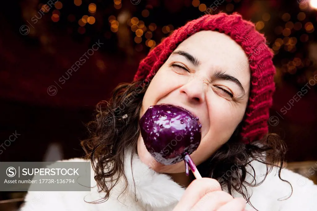 Woman taking a bite of candied apple