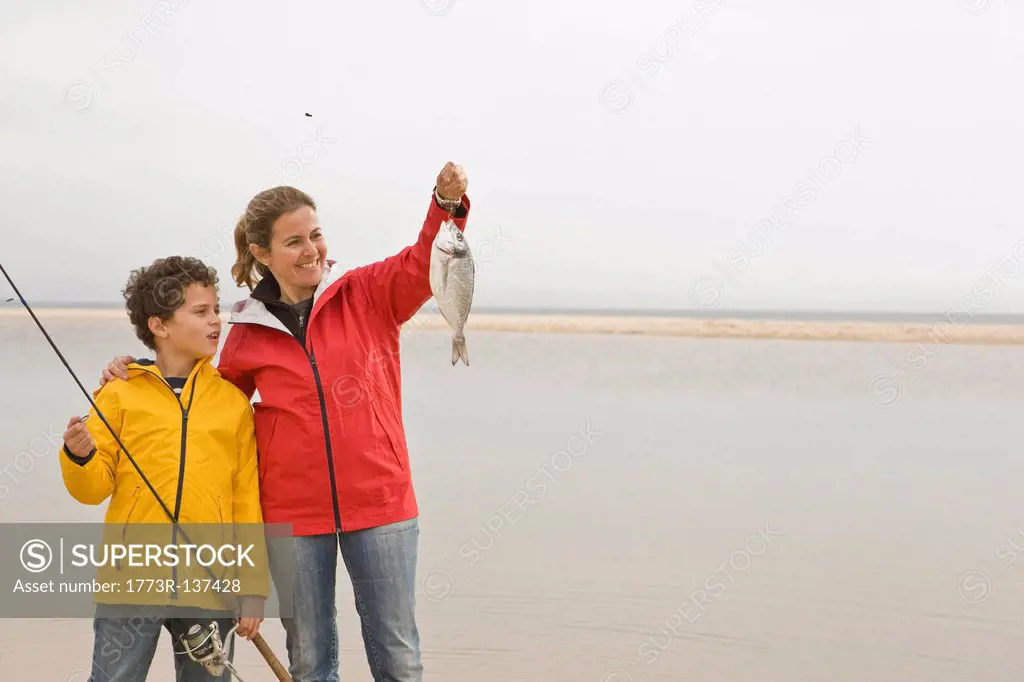 Mother and son looking proudly at fish