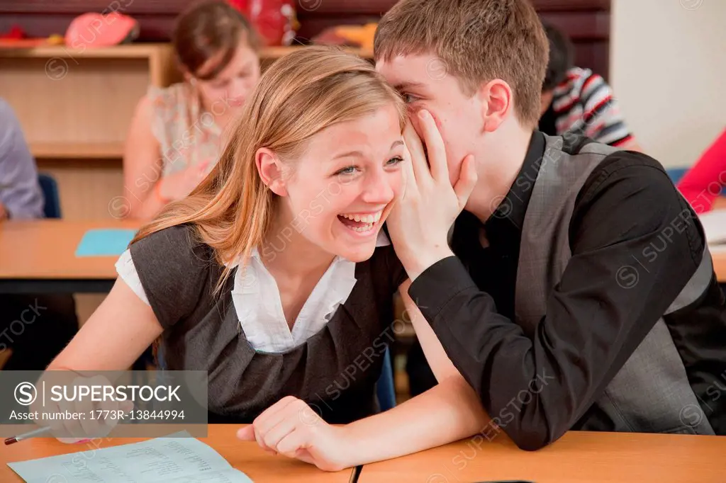 Two students share a secret in class