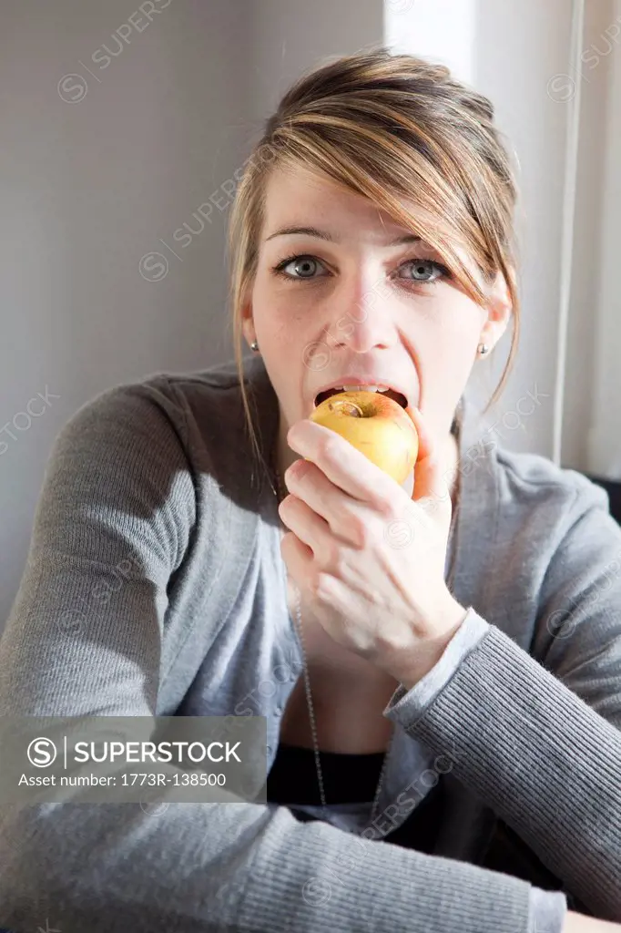 Young woman eating an apple