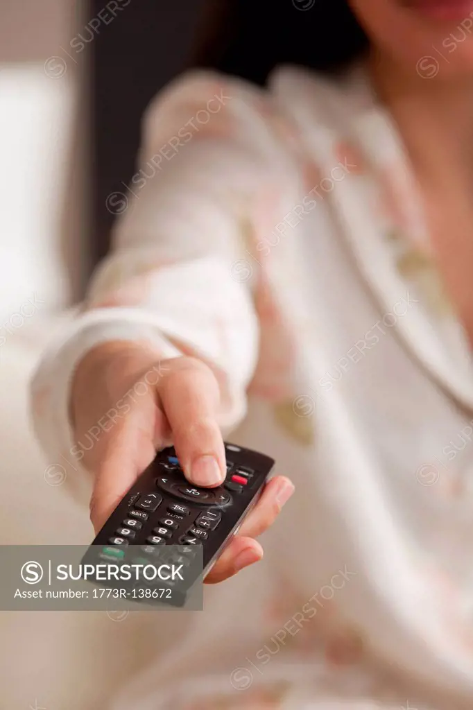 Close_up of female hand with TV remote