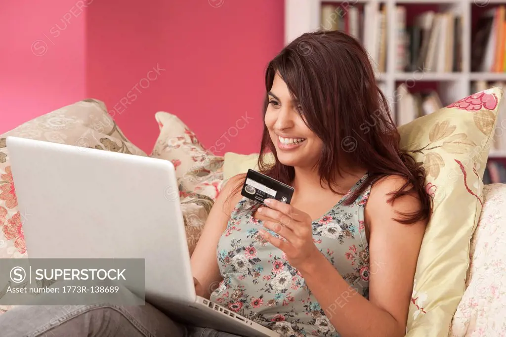 Young woman with credit card at laptop